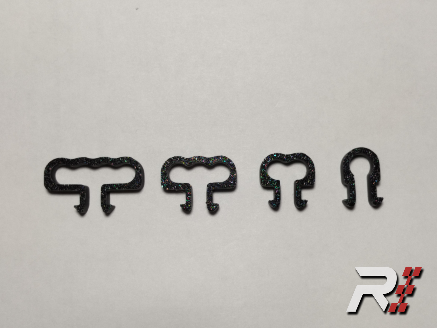 “RaceCraft 3D black snap-fit cable clip set with four different sizes displayed, including single, double, triple, and quad cable clips for sim racing rigs.”